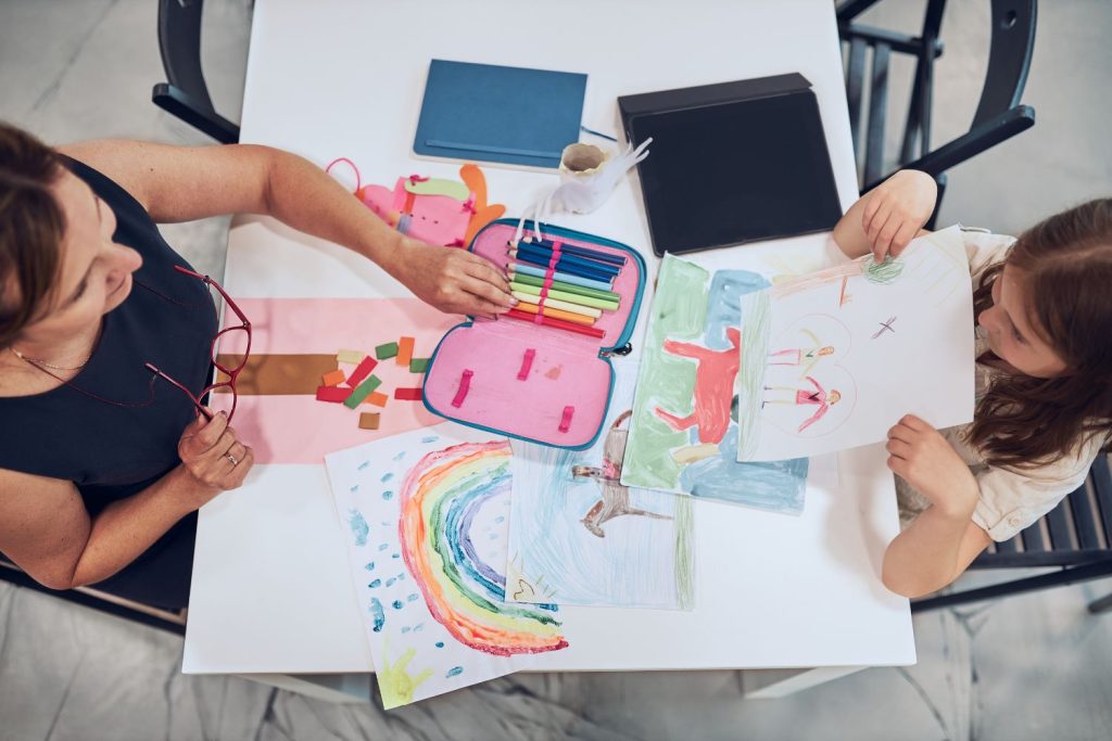 Woman teaching a kid to draw