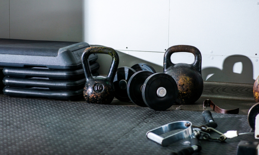 kettlebells, dumbbells, and step platforms in a gym